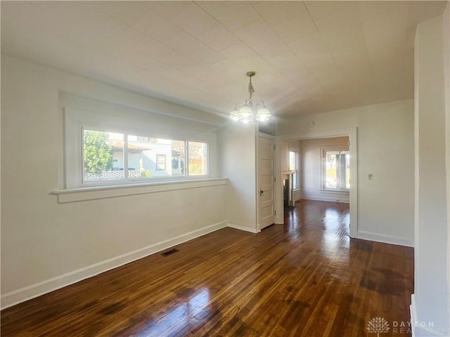 unfurnished dining area with dark hardwood / wood-style flooring and a notable chandelier