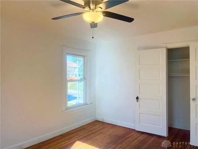 unfurnished bedroom featuring a closet, dark hardwood / wood-style floors, and ceiling fan