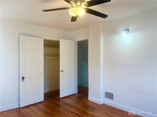 unfurnished bedroom with dark wood-type flooring, ceiling fan, and a closet