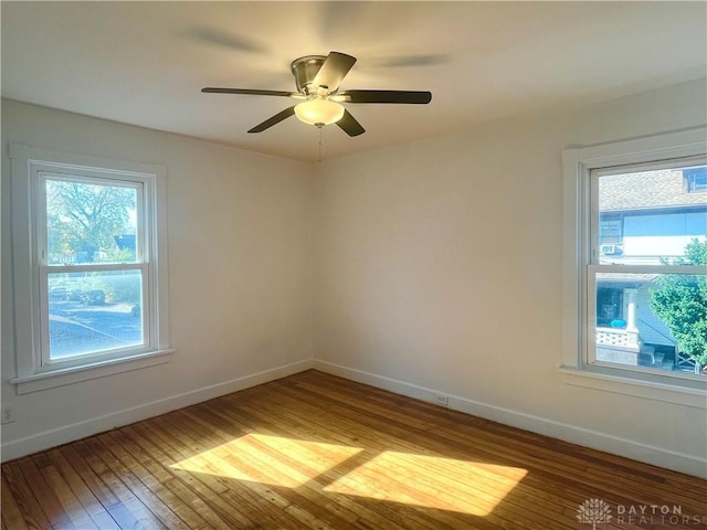 empty room with ceiling fan and hardwood / wood-style floors