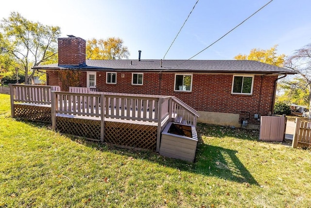 back of house featuring a lawn and a wooden deck