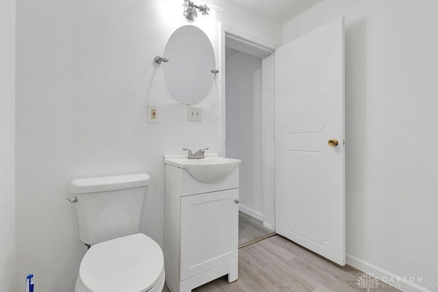 bathroom with vanity, wood-type flooring, and toilet