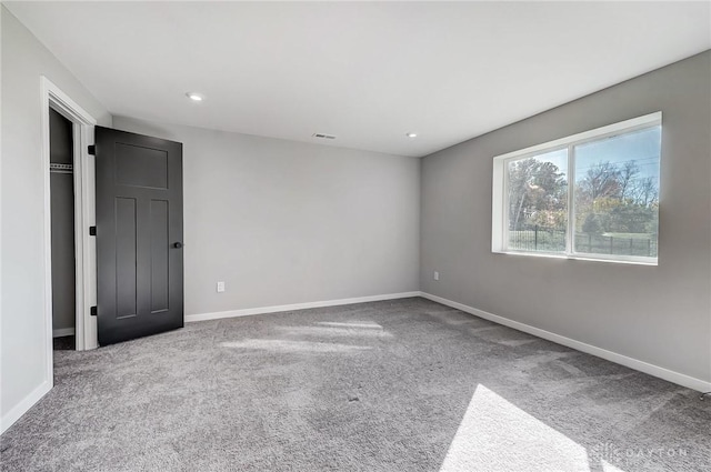 empty room featuring carpet floors, baseboards, and recessed lighting