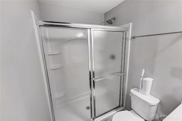 full bathroom with a stall shower and toilet