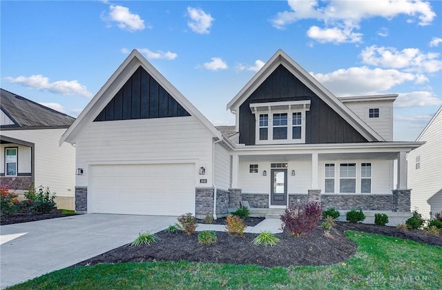 craftsman house featuring board and batten siding, stone siding, driveway, a porch, and a garage