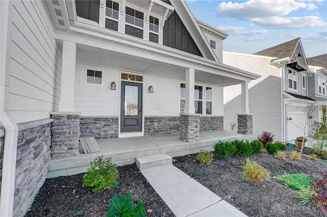 property entrance featuring a porch, board and batten siding, and stone siding