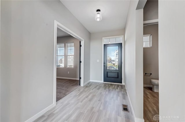 foyer entrance featuring light wood finished floors and baseboards