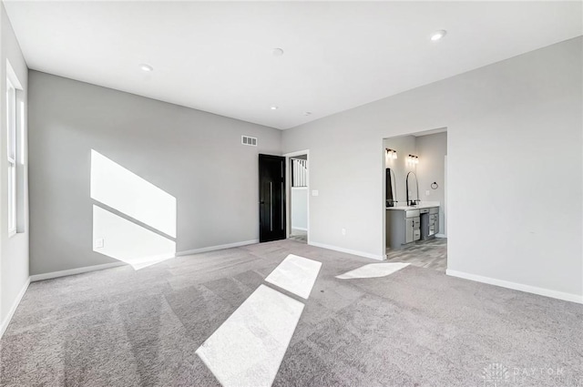 unfurnished bedroom with light colored carpet, baseboards, ensuite bathroom, and recessed lighting