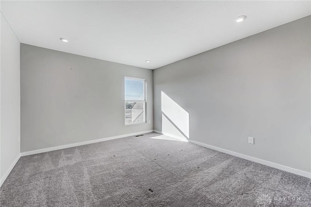 carpeted spare room featuring baseboards and recessed lighting