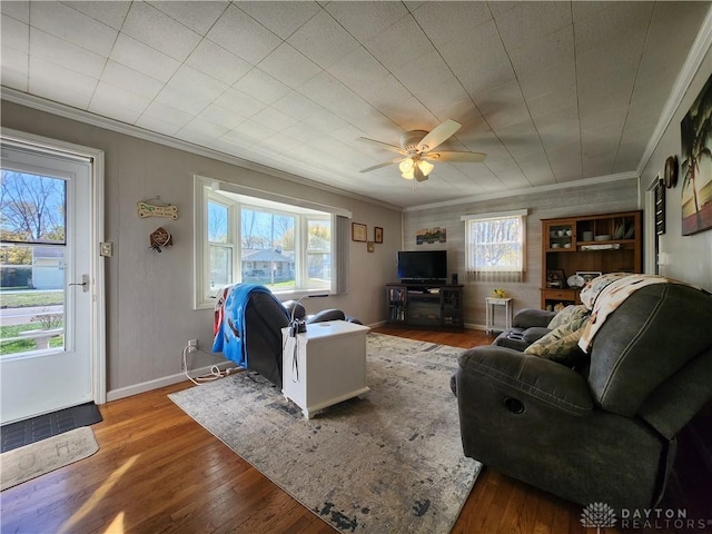 living room with ornamental molding, wood-type flooring, and ceiling fan