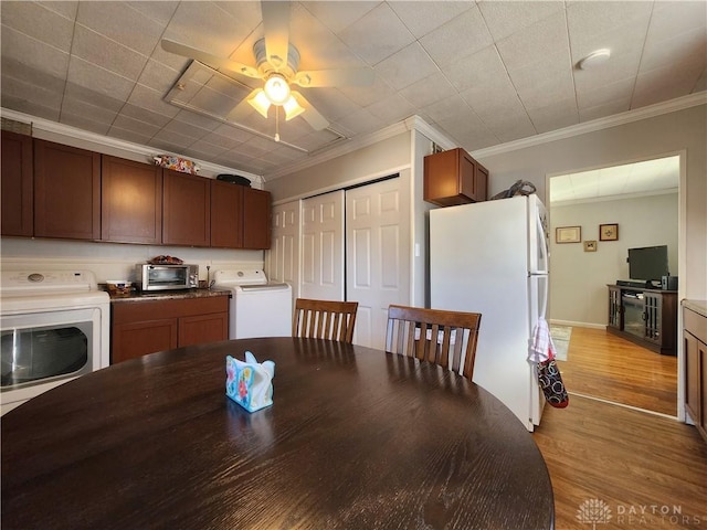 kitchen featuring crown molding, washer / dryer, white fridge, and light hardwood / wood-style floors