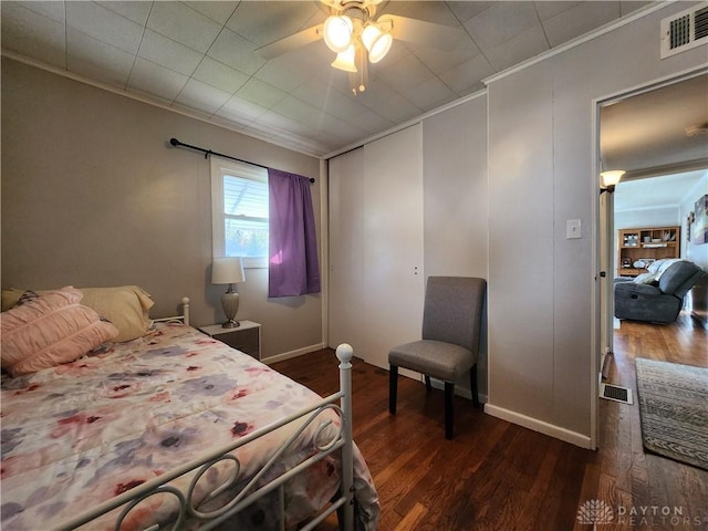 bedroom with ornamental molding, dark hardwood / wood-style floors, and ceiling fan