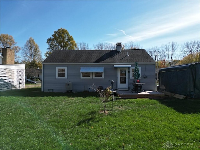 back of property featuring a deck and a lawn