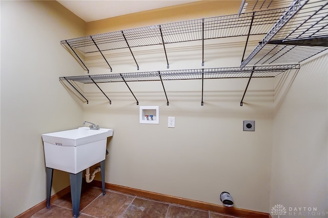 washroom with electric dryer hookup, washer hookup, and dark tile patterned flooring