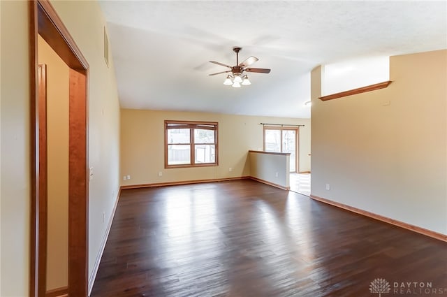 empty room featuring vaulted ceiling, ceiling fan, and dark hardwood / wood-style flooring