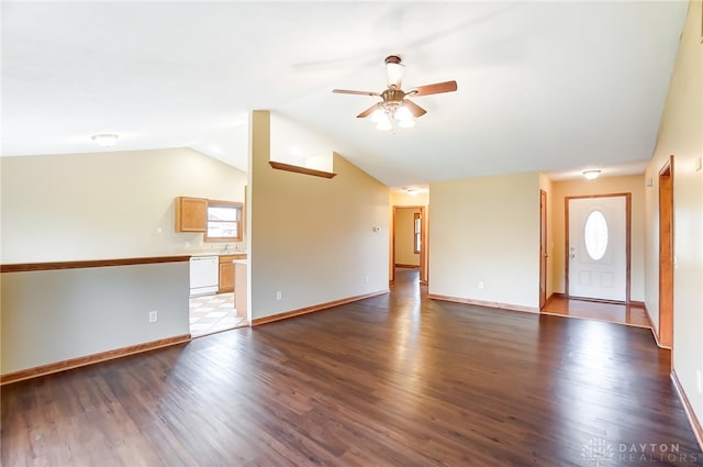 unfurnished living room featuring vaulted ceiling, a healthy amount of sunlight, and dark hardwood / wood-style flooring