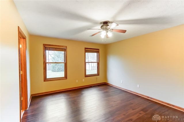 spare room with ceiling fan and dark wood-type flooring