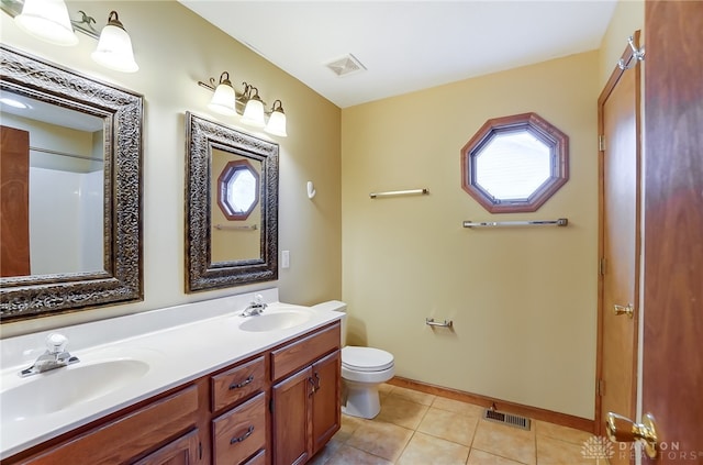 bathroom with tile patterned flooring, vanity, and toilet