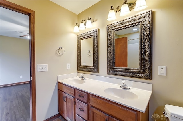 bathroom with vanity, hardwood / wood-style flooring, toilet, and ceiling fan