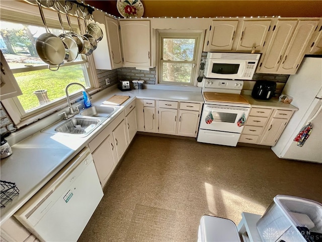 kitchen with white appliances, sink, and tasteful backsplash