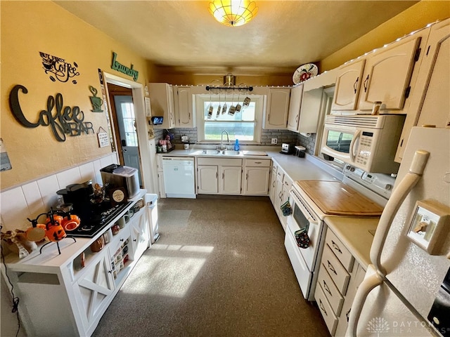 kitchen with sink, white appliances, decorative backsplash, and white cabinets