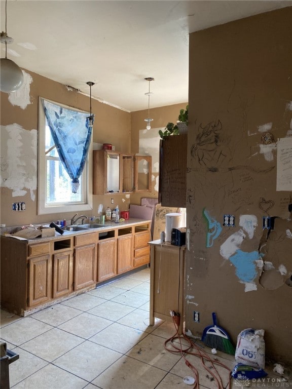 kitchen featuring light tile patterned floors, decorative light fixtures, and sink