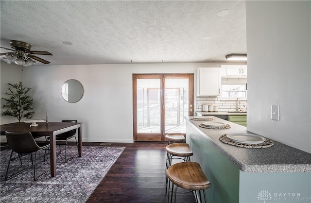 interior space with sink, dark hardwood / wood-style floors, a textured ceiling, and ceiling fan