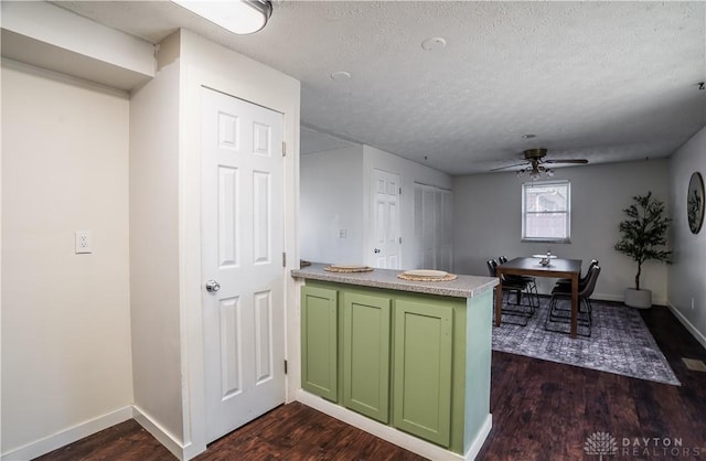 kitchen featuring ceiling fan, dark hardwood / wood-style floors, green cabinets, and a textured ceiling