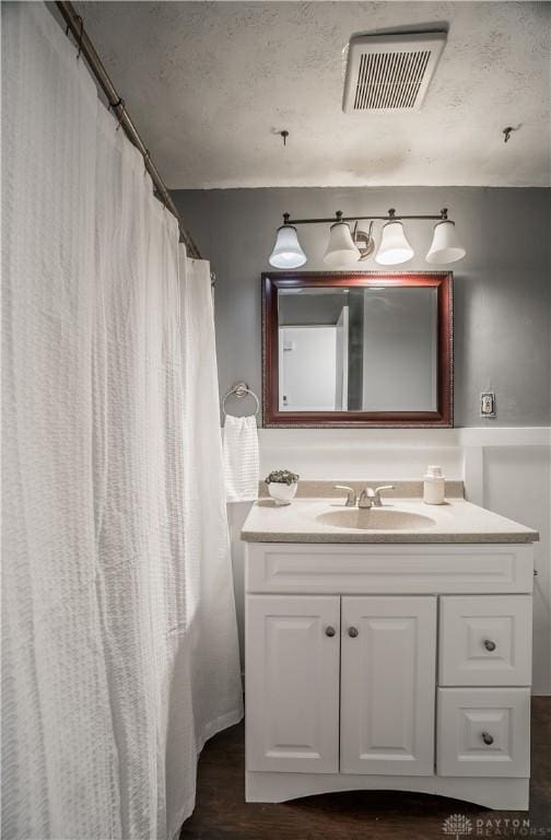 bathroom with vanity, hardwood / wood-style floors, and a textured ceiling