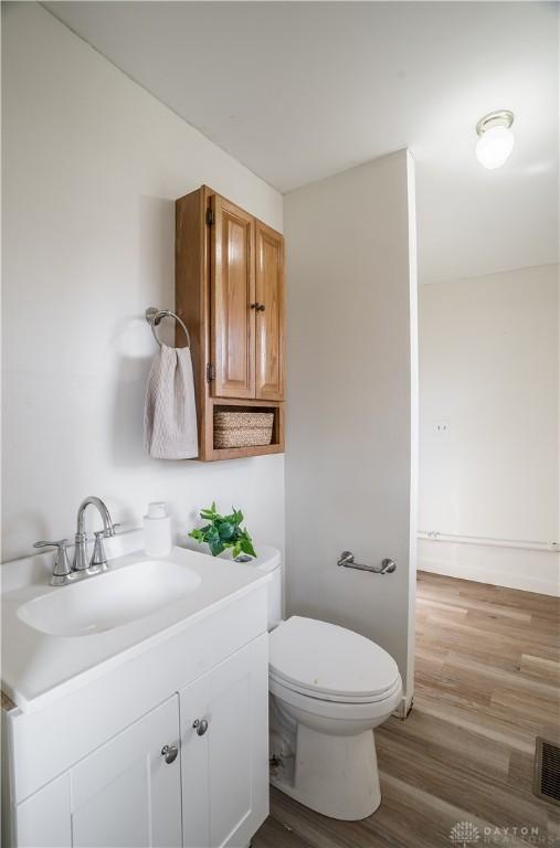 bathroom featuring hardwood / wood-style flooring, vanity, and toilet