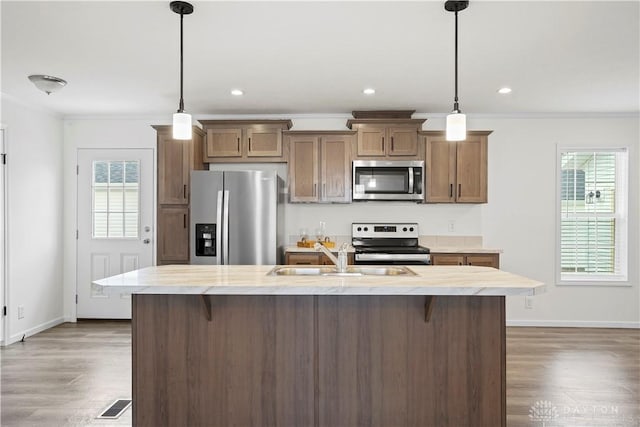 kitchen featuring hanging light fixtures, appliances with stainless steel finishes, plenty of natural light, and sink