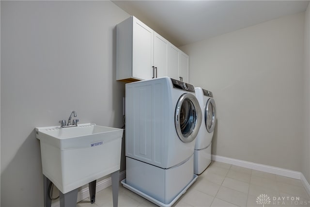 washroom with sink, cabinets, and washing machine and clothes dryer