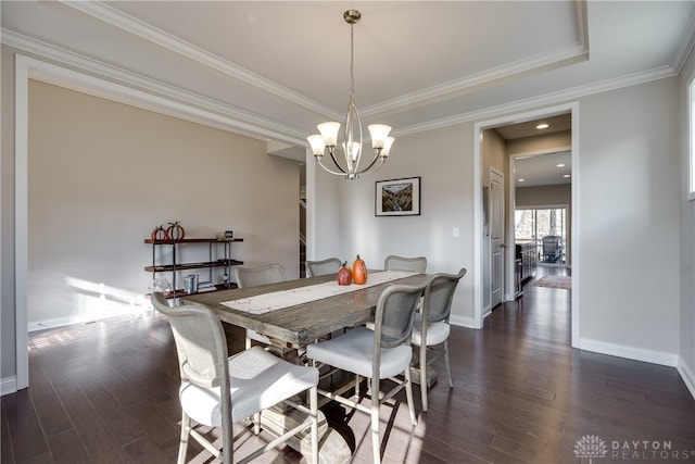 dining space featuring dark wood-type flooring, an inviting chandelier, and crown molding