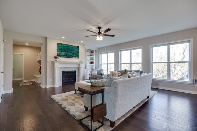 living room with ceiling fan, built in features, and dark hardwood / wood-style flooring