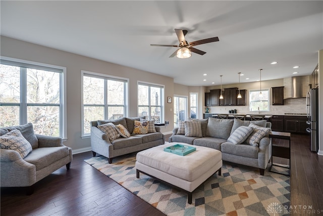 living room with ceiling fan, dark hardwood / wood-style floors, and sink