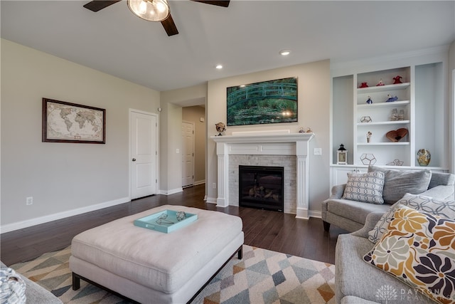 living room with built in features, ceiling fan, and dark hardwood / wood-style floors