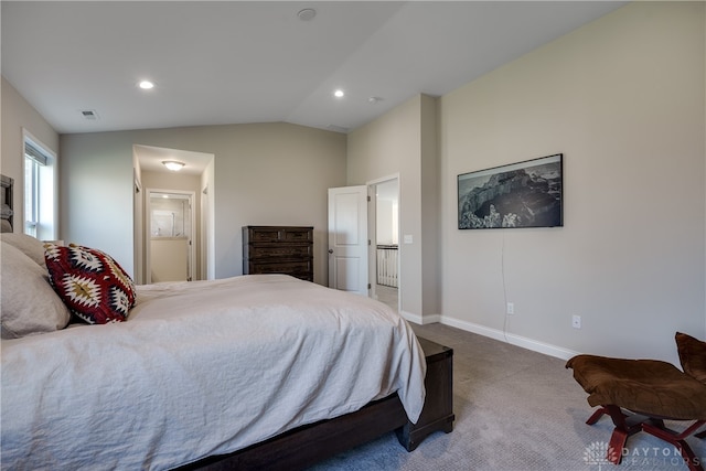 bedroom featuring vaulted ceiling, carpet flooring, and ensuite bath