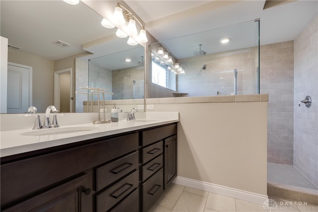 bathroom with vanity and a tile shower