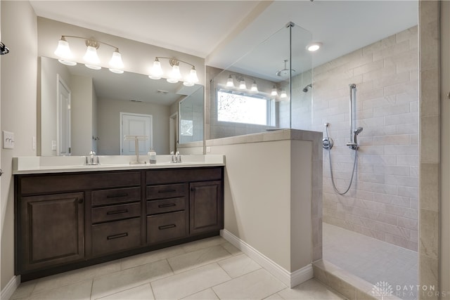 bathroom featuring vanity, tile patterned flooring, and tiled shower