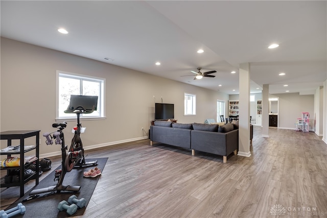 workout area featuring light wood-type flooring and ceiling fan