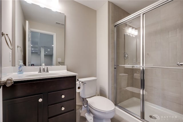 bathroom with walk in shower, vanity, and toilet