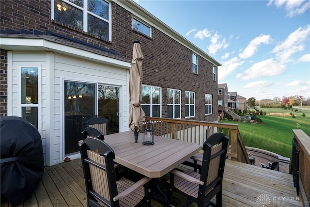 wooden deck featuring a grill and a yard