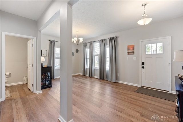 foyer entrance featuring light wood-type flooring and an inviting chandelier