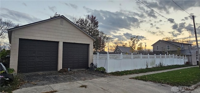 view of garage at dusk