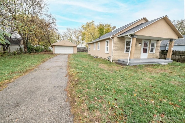 view of front of home featuring an outbuilding, a garage, covered porch, and a front lawn