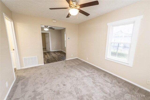 unfurnished room featuring a textured ceiling, carpet floors, and ceiling fan