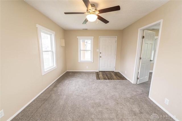 carpeted foyer entrance with ceiling fan