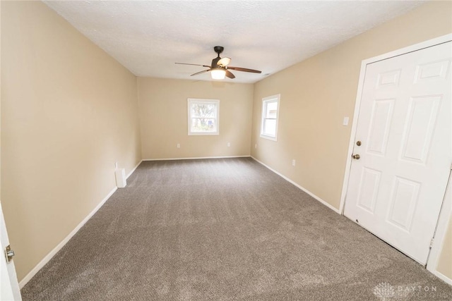 carpeted spare room with ceiling fan and a textured ceiling