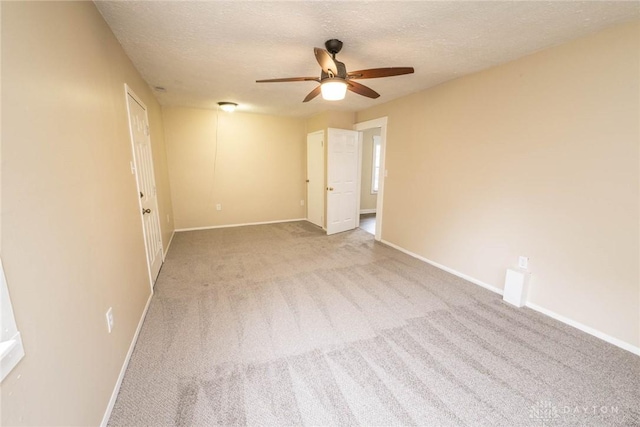 carpeted empty room featuring ceiling fan and a textured ceiling