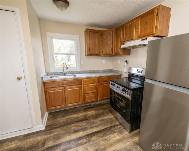 kitchen featuring stainless steel appliances, sink, a textured ceiling, and dark hardwood / wood-style flooring